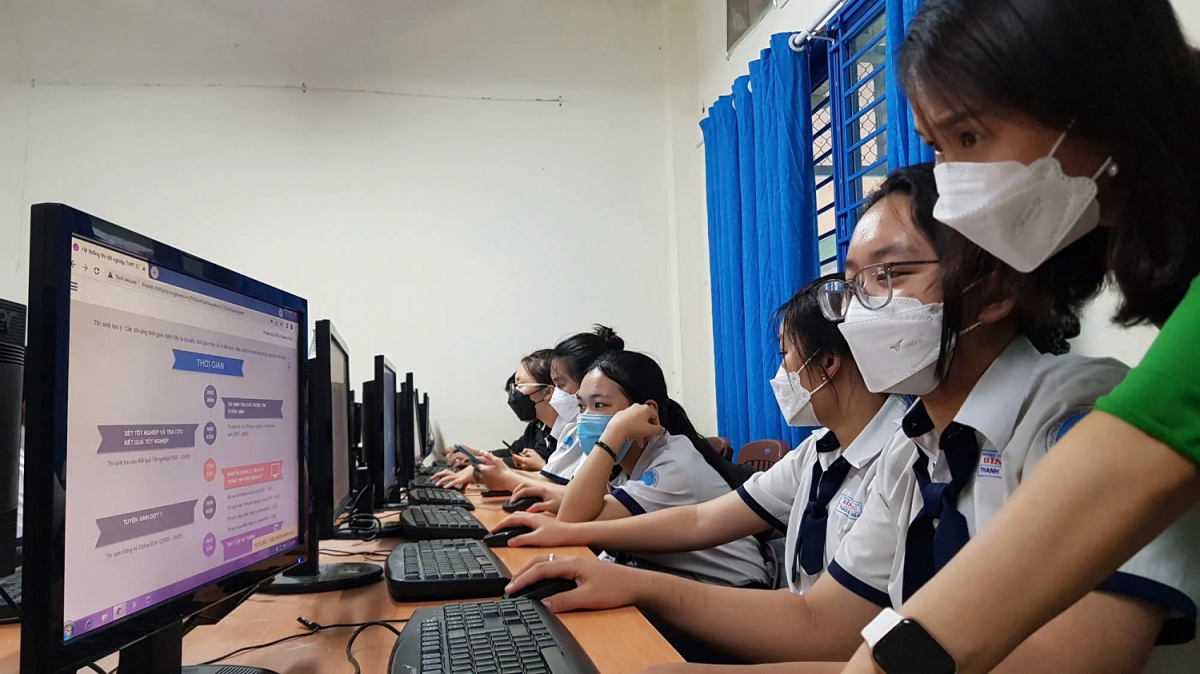 Học sinh lớp 12 thao tác đăng ký xét tuyển trực tuyến qua hệ thống VNeID trong giờ học tin học tại trường THPT.