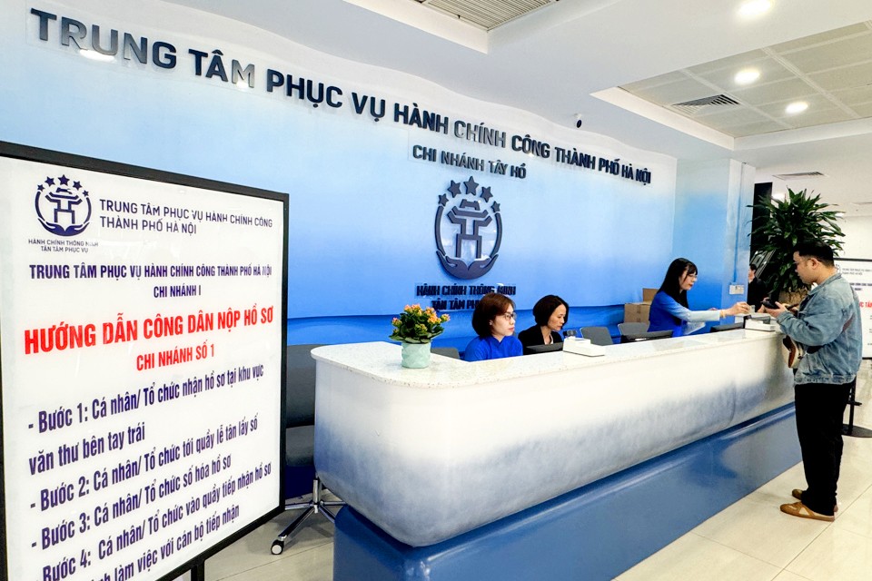 Cán bộ Trung tâm Phục vụ hành chính công TP. Hà Nội hướng dẫn người dân hoàn thiện hồ sơ thủ tục hành chính. Ảnh: VGP/Minh Anh