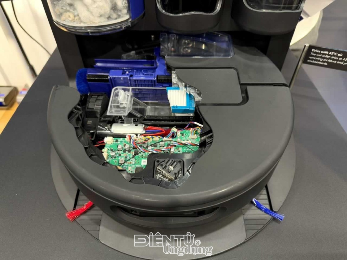 Cấu trúc nội tạng robot hút bụi lau nhà Dyson Spot+Scrub Ai gồm bo mạch điều khiển, bình chứa nước và cơ cấu con lăn ướt màu xanh bên trong thân máy cao 110mm
