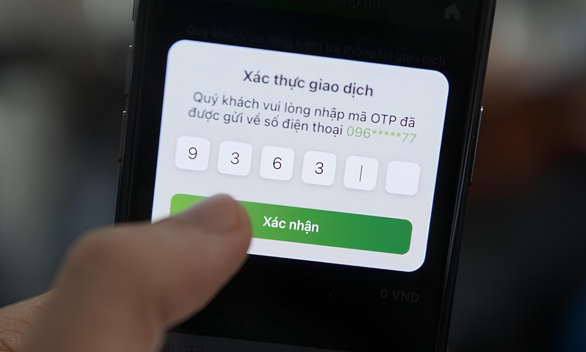 Người dùng xác thực giao dịch trực tuyến bằng mã OTP trên điện thoại di động, bước bảo mật phổ biến trong ngân hàng số hiện nay.