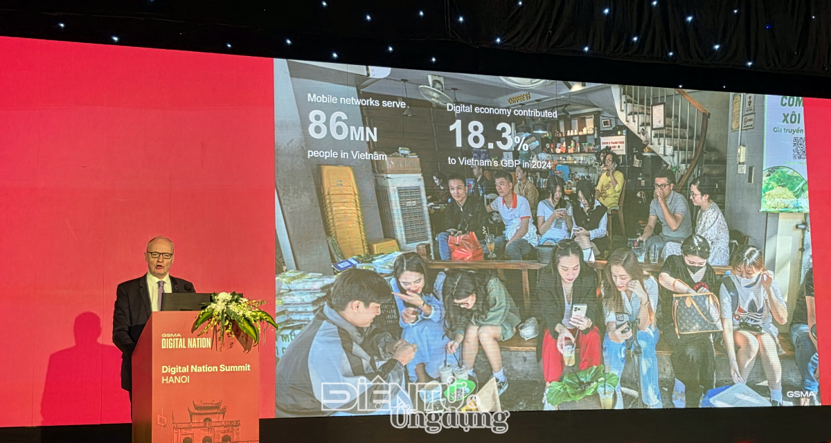 Ông Alex Sinclair, Giám đốc Công nghệ GSMA, trình bày tại Hội nghị Thượng đỉnh Số GSMA Hà Nội ngày 26/5/2026, với hai con số được chiếu lên màn hình lớn minh họa cho luận điểm về hạ tầng viễn thông Việt Nam: mạng di động đang phục vụ 86 triệu người dùng và kinh tế số đóng góp 18,3% GDP năm 2024