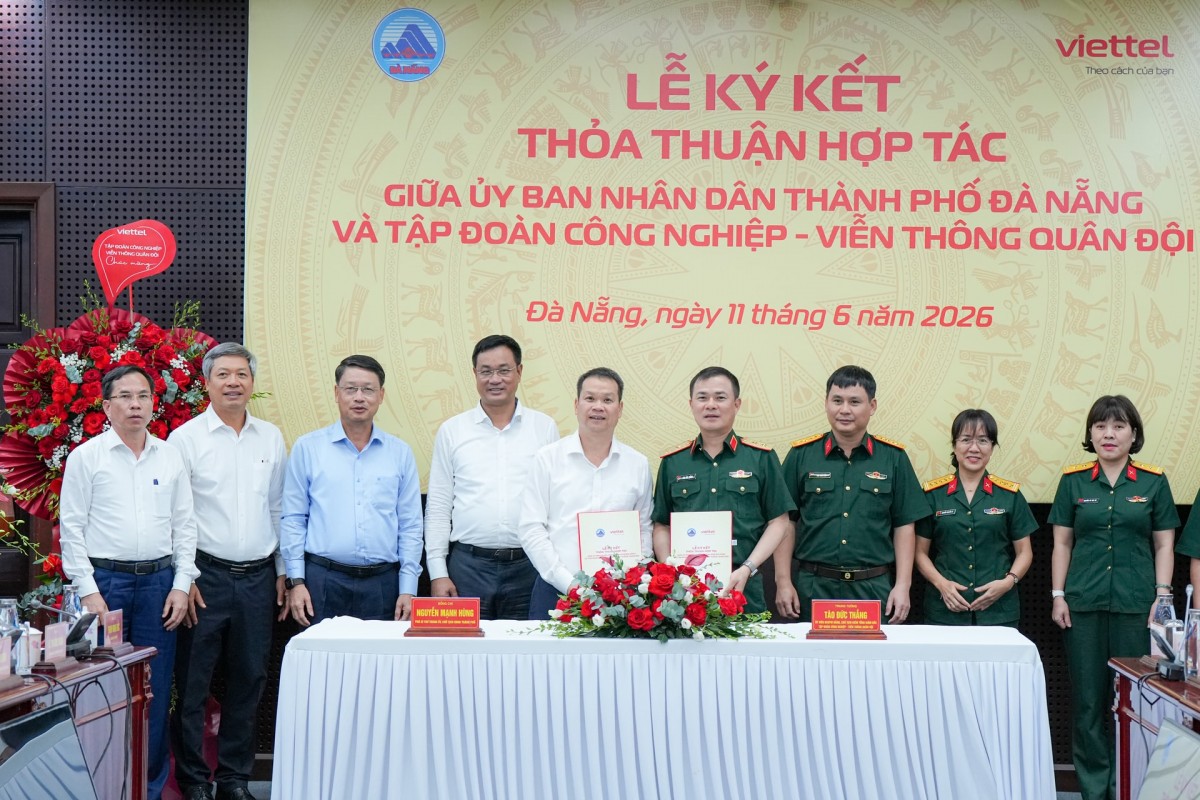 Bí thư Thành ủy Lê Ngọc Quang (thứ 4, bên trái sang) cùng các đại biểu chứng kiến lễ ký kết thỏa thuận hợp tác giữa UBND thành phố Đà Nẵng với Viettel. 