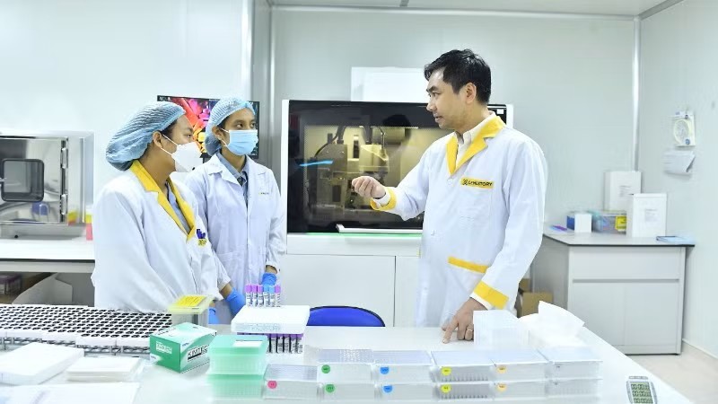 Tiến sĩ Võ Sỹ Nam đang thảo luận với cộng sự về các công nghệ giải mã gene (Ảnh: nhandan.vn)
