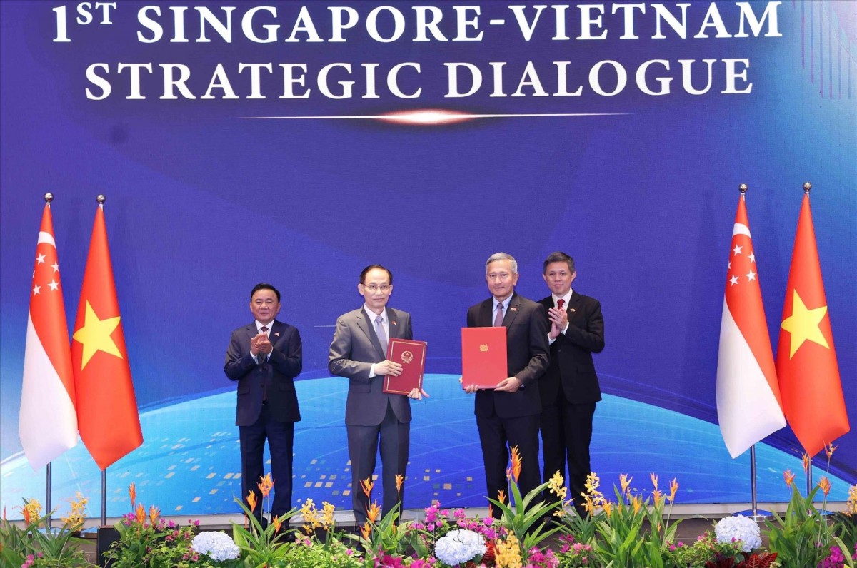 Ủy viên Bộ Chính trị, Bộ trưởng Ngoại giao Lê Hoài Trung và Bộ trưởng Ngoại giao Singapore Vivian Balakrishnan trao Bản ghi nhớ hợp tác giữa hai Đảng. (Ảnh: Phương Hoa/TTXVN)