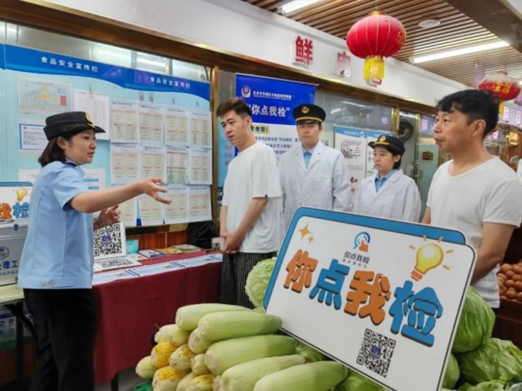 Cán bộ kiểm tra an toàn thực phẩm tại chợ nông sản cùng người tiêu dùng chọn mẫu
