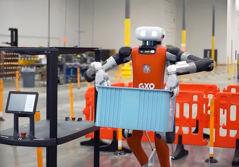Robot hình người Digit vận chuyển thùng chứa hàng trong kho GXO. Ảnh: TechSpot. Robot hình người Digit vận chuyển thùng chứa hàng trong kho GXO. Ảnh: TechSpot.
